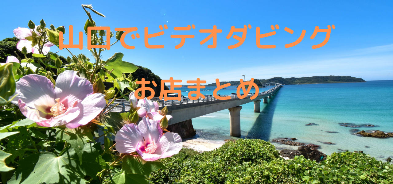 ピンク色の花が咲いていて青い海に大きな橋が架かっている