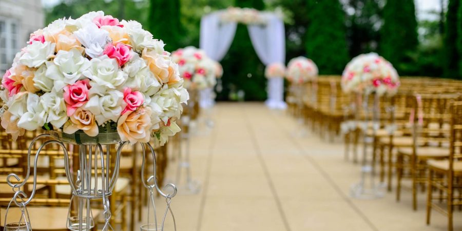 両側にいずが並んでいて、花束のブーケが添えられている結婚式場